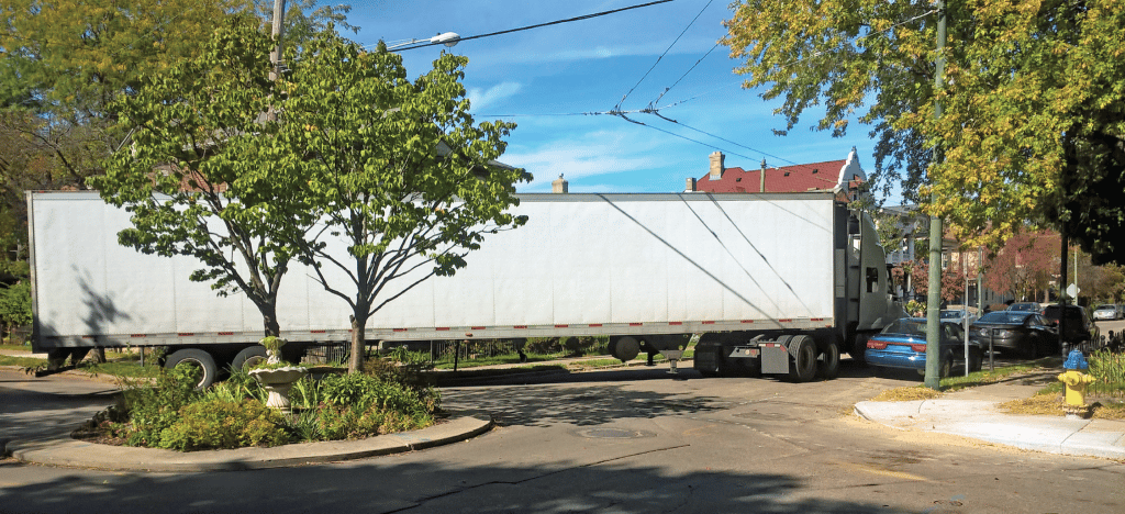 semi truck turning through a round about in a residential area