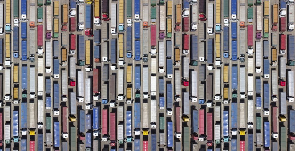 aerial view of hundreds of semi trucks lined up in multiple lanes