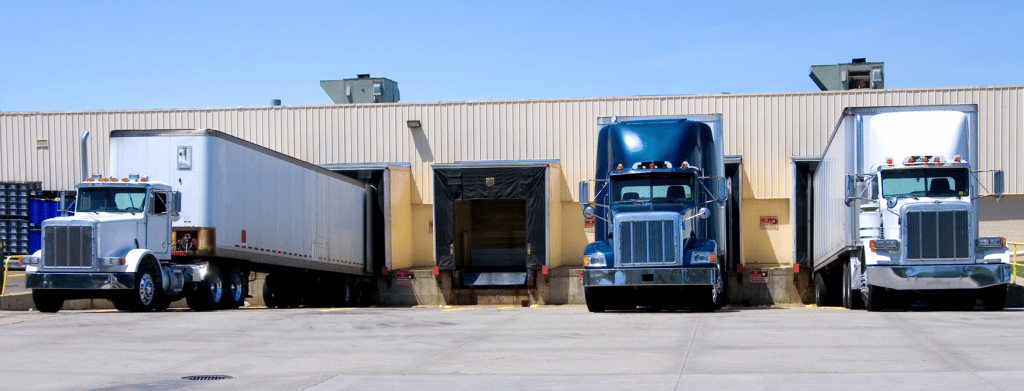 four semi-trucks in a loading dock